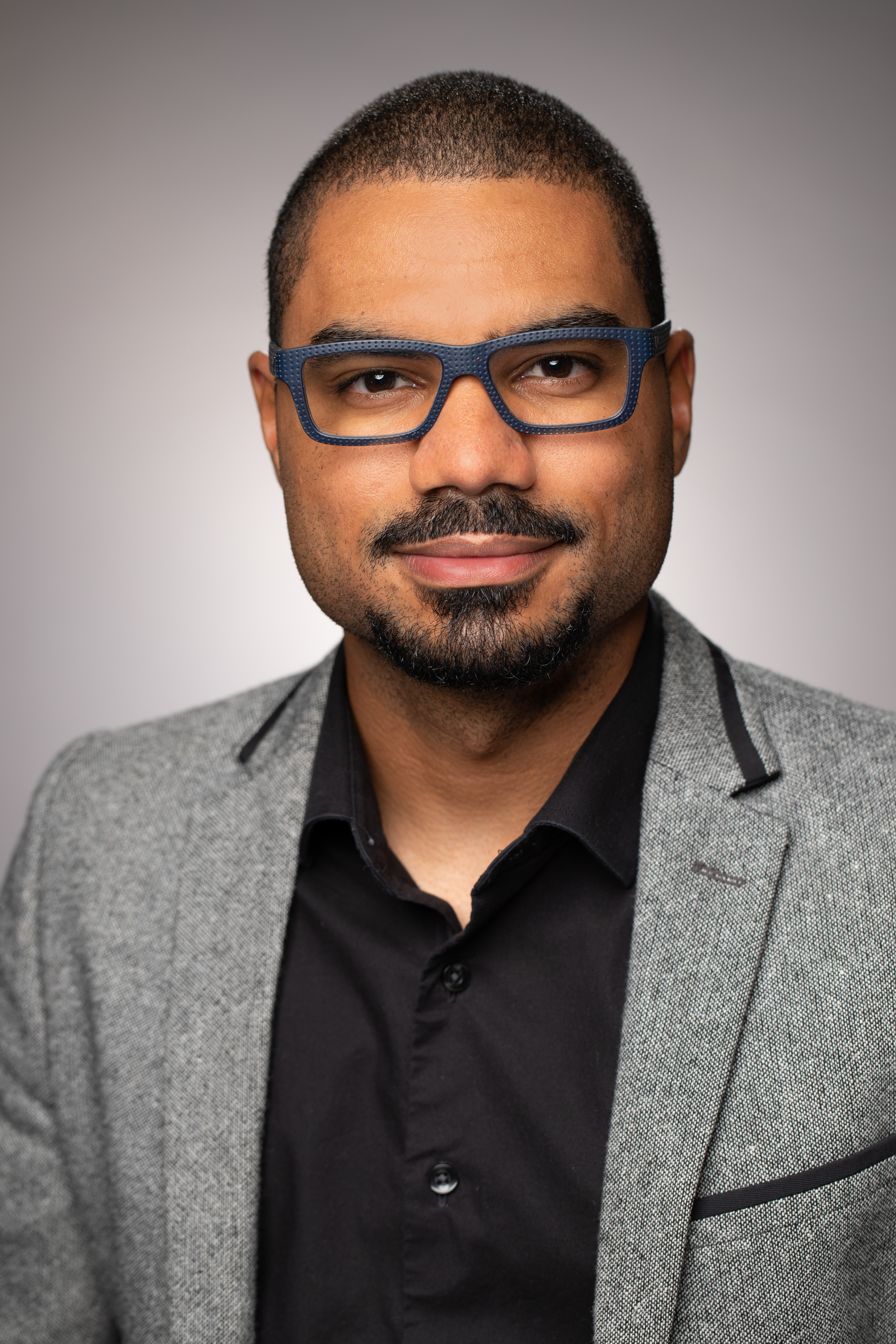 Lorenz Parisot wearing glasses and a gray blazer